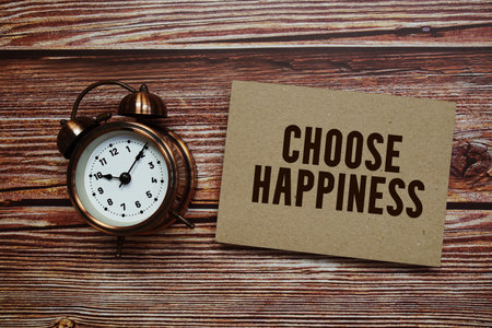 Choose Happiness text with alarm clock on wooden backgroundの写真素材