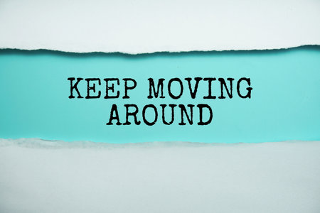 Keep Moving Around message written on blue paper with torn paper backgroundの写真素材