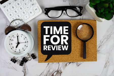 Time For Review text with Calculator, alarm clock and magnifying glass on marble background