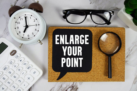 Enlarge Your Point text with Calculator, alarm clock and magnifying glass on marble background