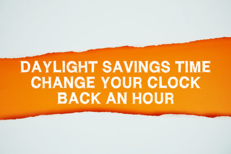 Daylight Saving Time text on orange with white paper torn ripped of horizontalの写真素材