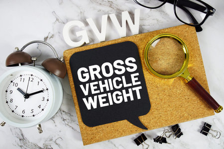GVW Gross Vehicle Weight acronym with alarm clock and magnifying glass, business concept background