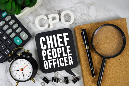 CPO Chief People Officer text with Calculator, alarm clock and magnifying glass on marble backgroundの写真素材