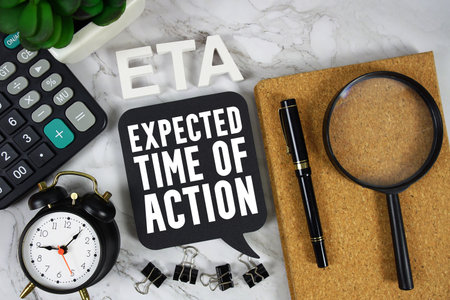 ETA Expected Time Of Action text with Calculator, alarm clock and magnifying glass on marble backgroundの写真素材