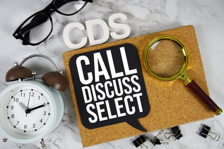 CDS Call Discuss Select text with alarm clock and magnifying glass on marble background