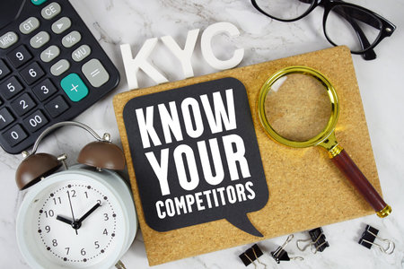 KYC Know Your Competitors text with Calculator, alarm clock and magnifying glass on marble backgroundの写真素材