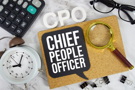 CPO Chief People Officer text with Calculator, alarm clock and magnifying glass on marble backgroundの写真素材