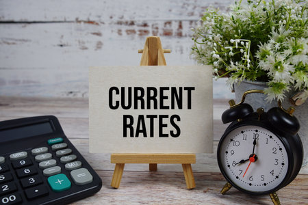 Current Rates text with alarm clock and calculator on wooden backgroundの写真素材