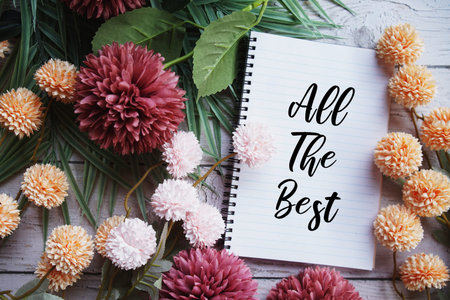 All The Best text message with flowers decoration on wooden background