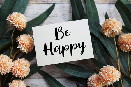 Be Happy Motivational and Inspirational quotes with flowers bouquet decoration on wooen background