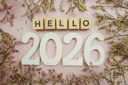 Hello 2026 Happy New Year with flower decoration on pink background
