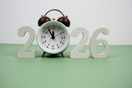 Happy new year 2026 and alarm clock on green background