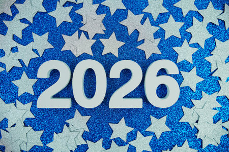 Happy New Year 2026 number and silver star confetti on blue glitter background