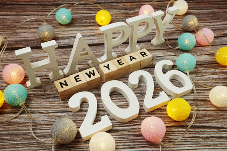 Happy New Year 2026 alphabet letter with LED cotton balls on wooden background