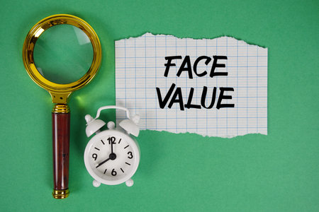 Face Value text written on paper with magnifying glass and alarm clock