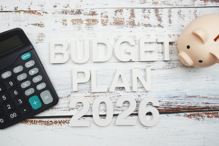 Budget Plan 2026 alphabet letter with calculator and piggy bank on wooden background