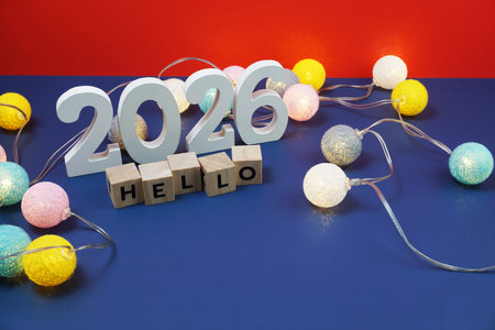 Hello 2026 alphabet letter and alarm clock decorate with LED cotton ball on blue and red background