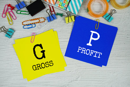 GP - Gross Profit text on stick note with stationery on concrete background
