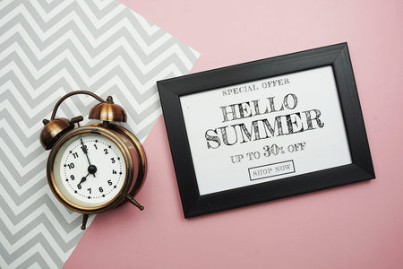 Hello Summer Sale 30% off with alarm clock on pink background