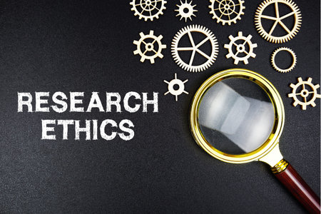 Research Ethics text message with magnifying glass on black background