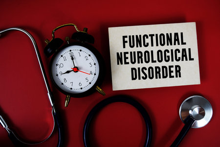 FND Functional Neurological Disorder text written on paper card with stethoscope and alarm clock on...