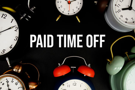 Paid Time Off text with alarm clock on black backgroundの写真素材