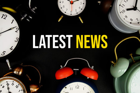Latest News text with alarm clock on black background