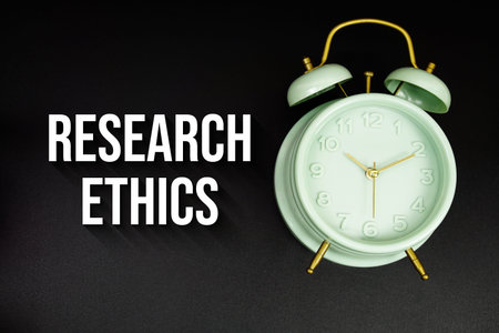 Research Ethics text with alarm clock on black background