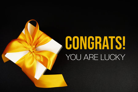 Congrats! You Are Lucky text with gift box present on black background