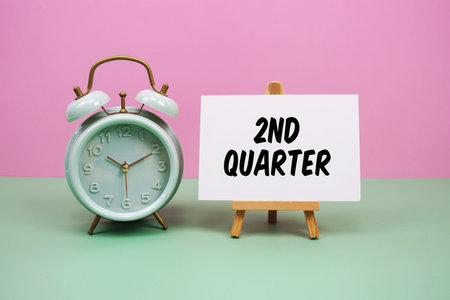 Second Quarter text with alarm clock on pink and green background