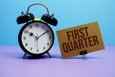 First Quarter text with alarm clock on blue and purple backgroundの写真素材