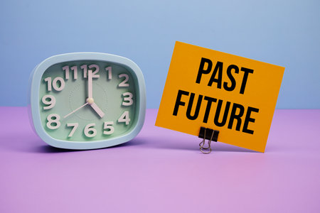 Past Future text and alarm clock on blue and purple backgroundの写真素材