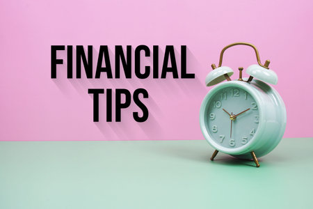 Black alarm clock on a pastel green and pink background with the text Financial Tips