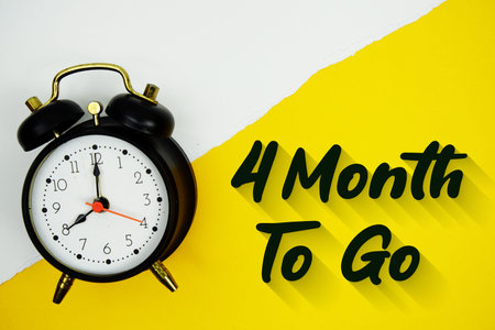 4 Month To Go text and alarm clock on yellow background