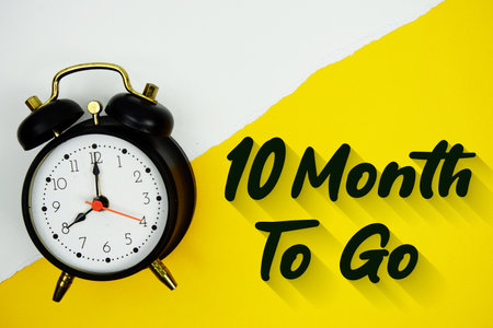 10 Month To Go text and alarm clock on yellow backgroundの写真素材