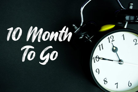 10 Month To Go text and alarm clock on black backgroundの写真素材