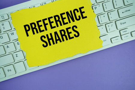 Yellow paper with text Preference Shares placed on a white keyboard