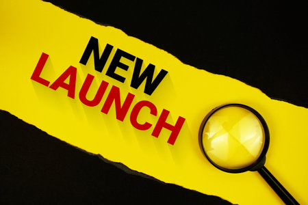 New Launch text on yellow with black paper torn ripped and magnifying glass