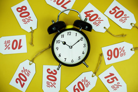 Clock surrounded by various discount tags with percentages like 10%, 20%, 30%, up to 90% off, set...