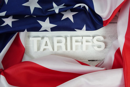 Tariffs alaphbet letters with usa flag on wooden backgroundの写真素材