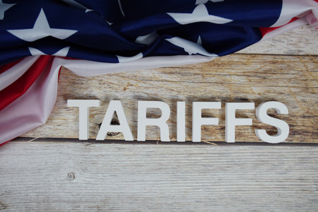 Tariffs alaphbet letters with usa flag on wooden backgroundの写真素材