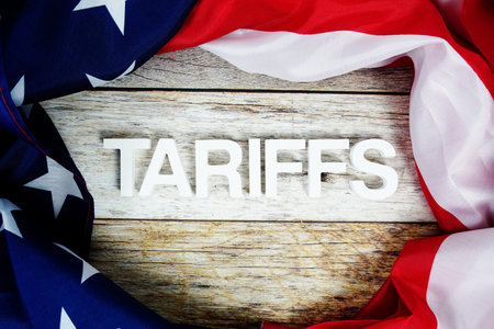 Tariffs alaphbet letters with usa flag on wooden background