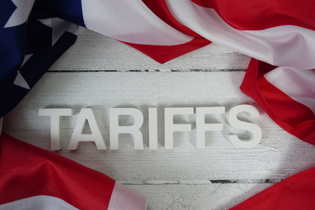 Tariffs alaphbet letters with usa flag on wooden backgroundの写真素材