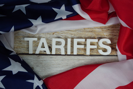 Tariffs alaphbet letters with usa flag on wooden backgroundの写真素材