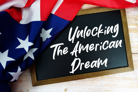 American flag with blackboard  "Unlocking the American Dream" on wooden backgroundの写真素材