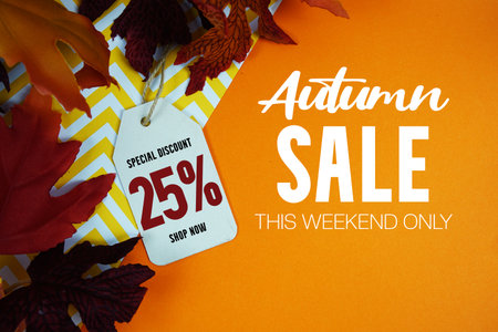 Autumn Sale 25% Off with Price Tag and maple leaf decorated on orange backgroundの写真素材