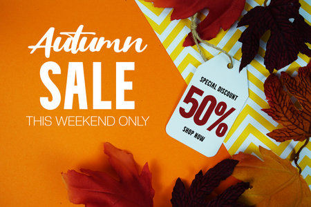 Autumn Sale 50% Off with Price Tag and maple leaf decorated on orange backgroundの写真素材