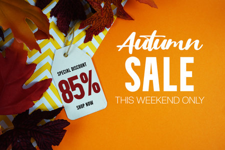 Autumn Sale 85% Off with Price Tag and maple leaf decorated on orange backgroundの写真素材