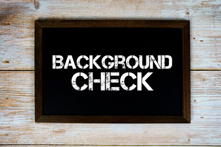 Background Check text written on blackboard flat lay on wooden backgroundの写真素材