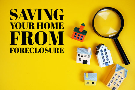 Saving Your Home From Foreclosuremodels text with house models and magnifying glass on yellow...